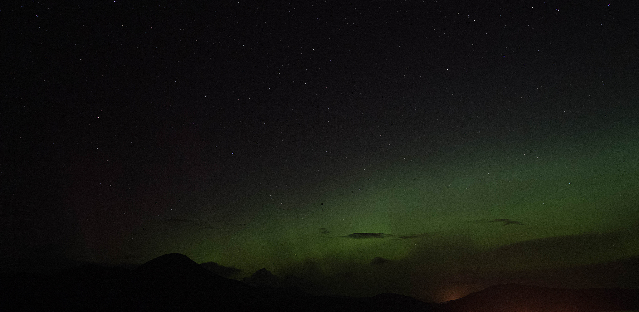 The northern lights above the golden glow of Broadford